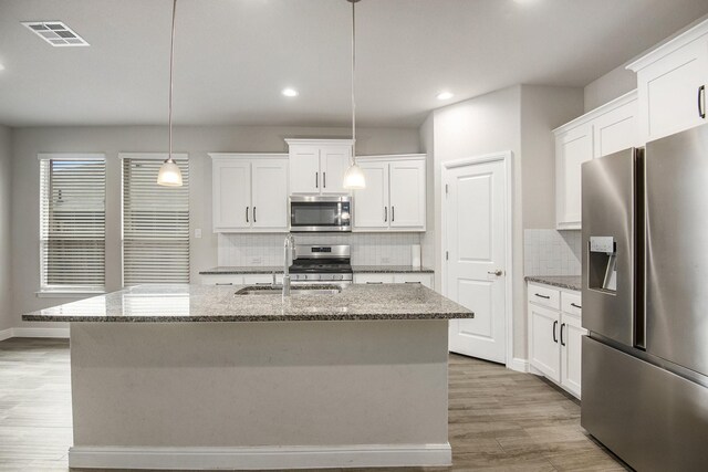 kitchen featuring white cabinetry, sink, an island with sink, and appliances with stainless steel finishes