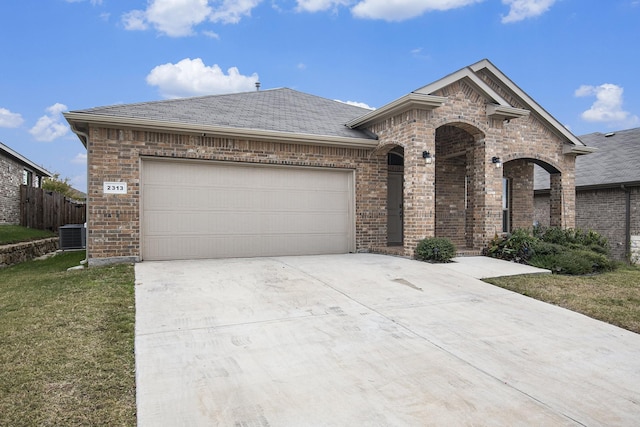 view of front facade featuring a garage, central air condition unit, and a front lawn