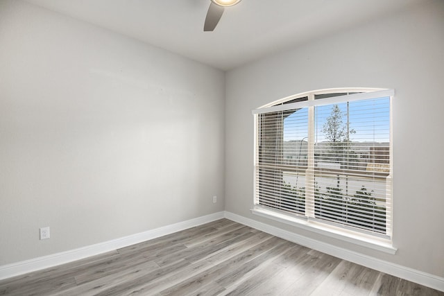 spare room featuring ceiling fan, baseboards, and wood finished floors