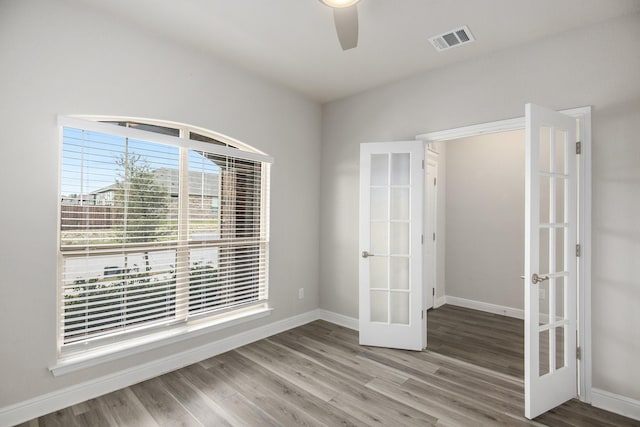 unfurnished room featuring hardwood / wood-style floors, ceiling fan, and french doors