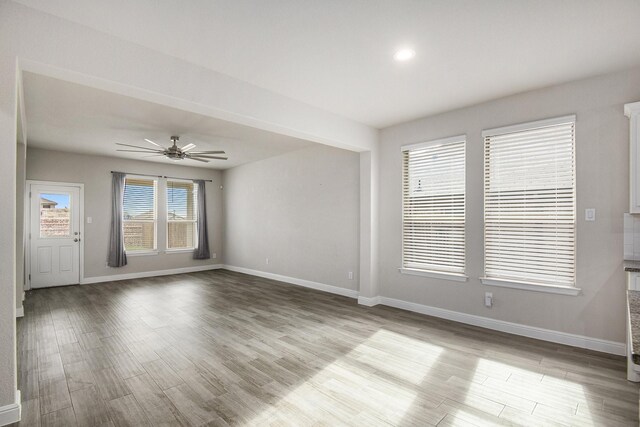 unfurnished living room with dark hardwood / wood-style floors and ceiling fan