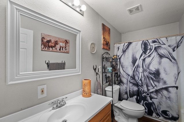 bathroom with vanity, a shower with curtain, a textured ceiling, and toilet