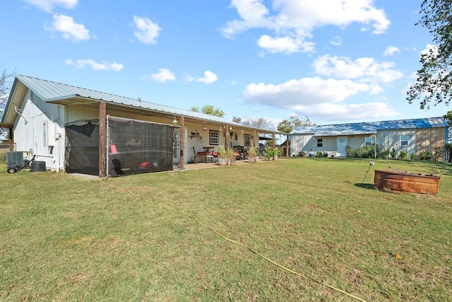 view of yard with central AC unit and an outbuilding