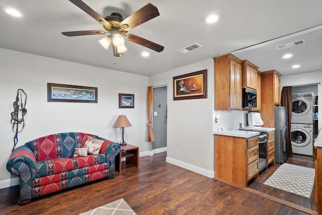 kitchen with ceiling fan, dark wood-type flooring, backsplash, stacked washer / dryer, and appliances with stainless steel finishes