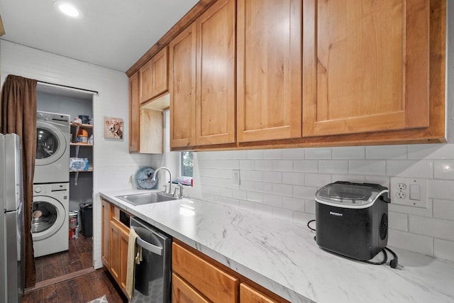 kitchen featuring backsplash, stainless steel appliances, dark wood-type flooring, sink, and stacked washer and clothes dryer