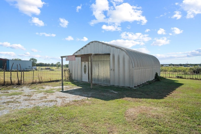 view of outbuilding with a rural view and a lawn