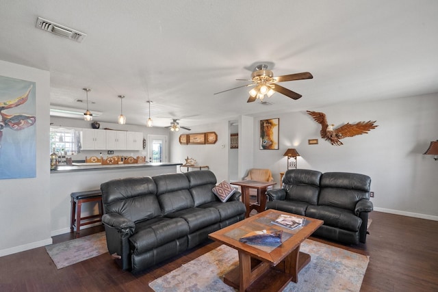 living room featuring ceiling fan and dark wood-type flooring