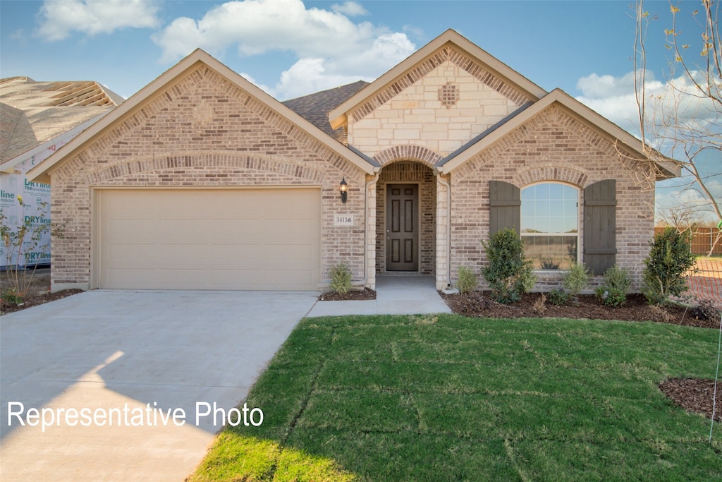 view of front of property with a garage and a front lawn