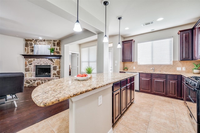 kitchen with gas stove, decorative backsplash, plenty of natural light, and a kitchen island