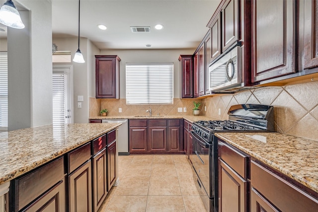 kitchen featuring tasteful backsplash, light stone counters, pendant lighting, and appliances with stainless steel finishes