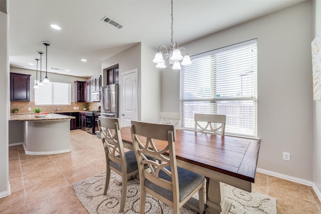 tiled dining space featuring a notable chandelier