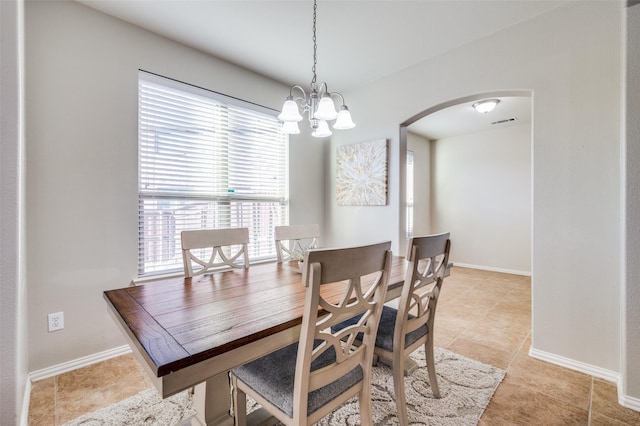 tiled dining room featuring a chandelier