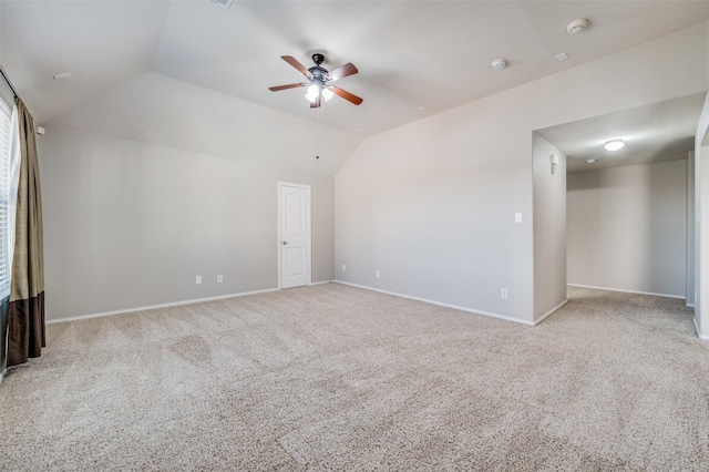 empty room featuring light carpet, vaulted ceiling, and ceiling fan