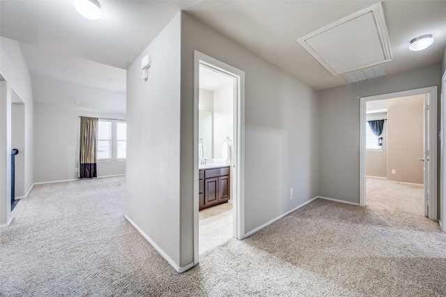 hallway featuring light colored carpet