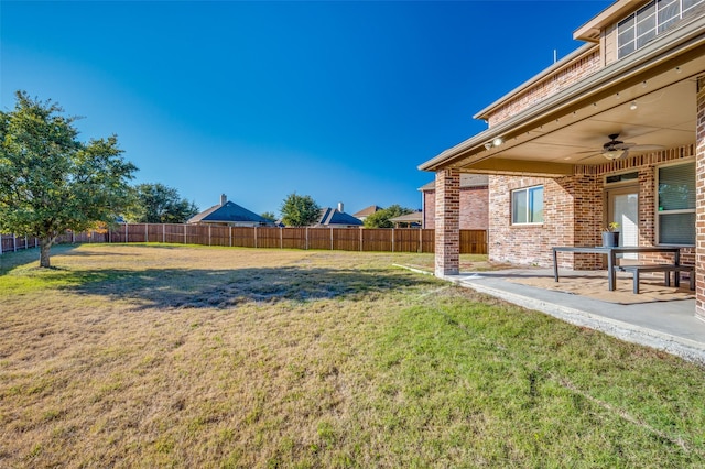 view of yard with ceiling fan and a patio area