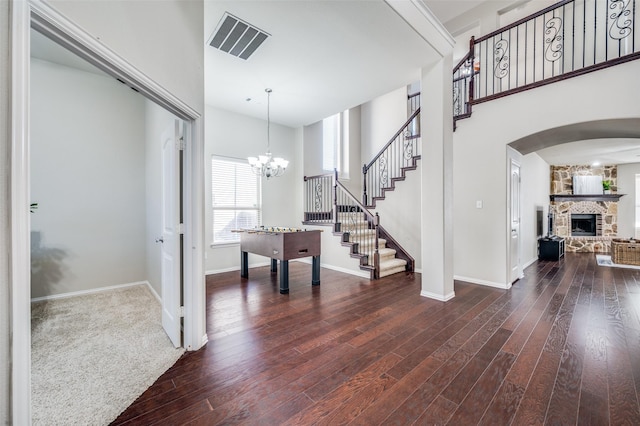 foyer featuring a fireplace, dark hardwood / wood-style flooring, and a towering ceiling