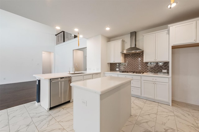 kitchen with marble finish floor, light countertops, appliances with stainless steel finishes, wall chimney range hood, and a peninsula