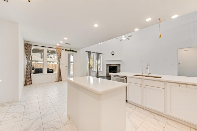 kitchen featuring open floor plan, a sink, marble finish floor, and a center island with sink