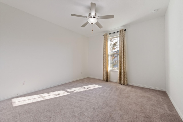 spare room with light carpet, ceiling fan, and baseboards