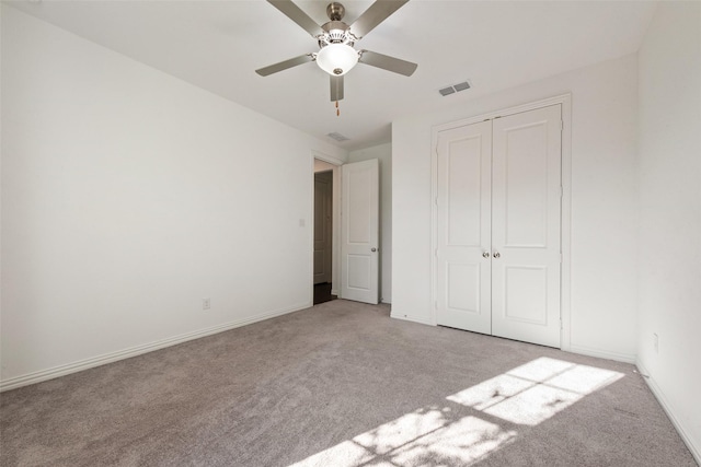 unfurnished bedroom with baseboards, visible vents, a closet, and light colored carpet