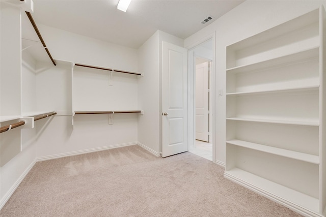 walk in closet featuring light carpet and visible vents