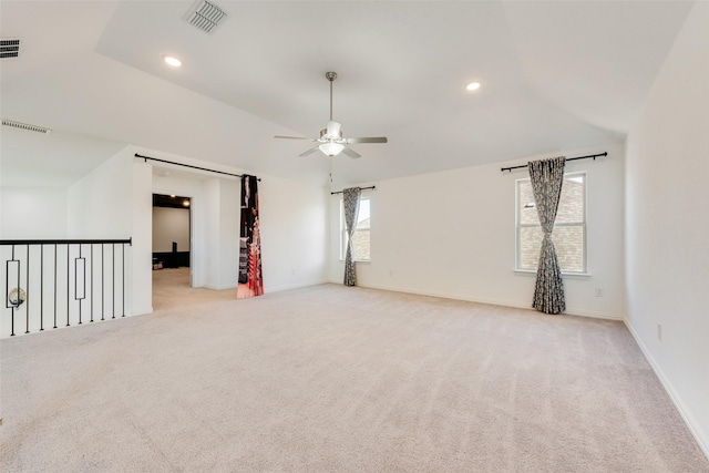 unfurnished room featuring lofted ceiling, light carpet, and visible vents