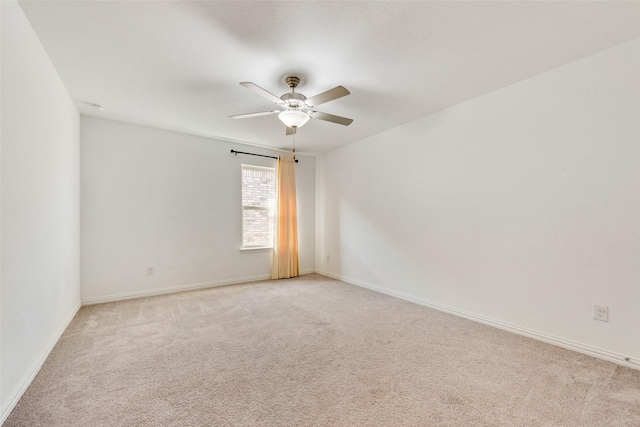 unfurnished room featuring a ceiling fan, light carpet, and baseboards