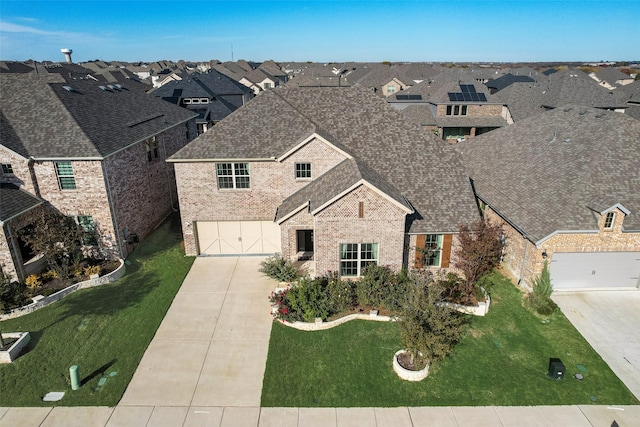 view of front of house with brick siding, a shingled roof, concrete driveway, a residential view, and a front lawn