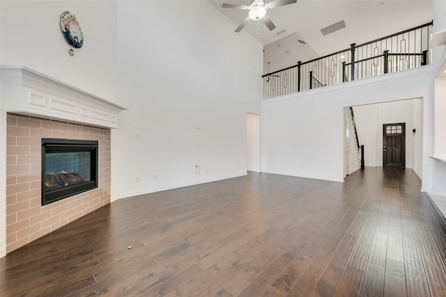 unfurnished living room with ceiling fan, dark wood-type flooring, a fireplace, and visible vents