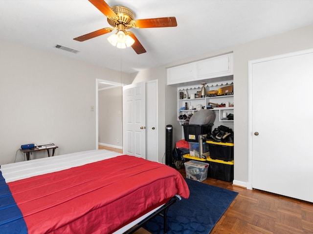 bedroom with ceiling fan and dark parquet floors