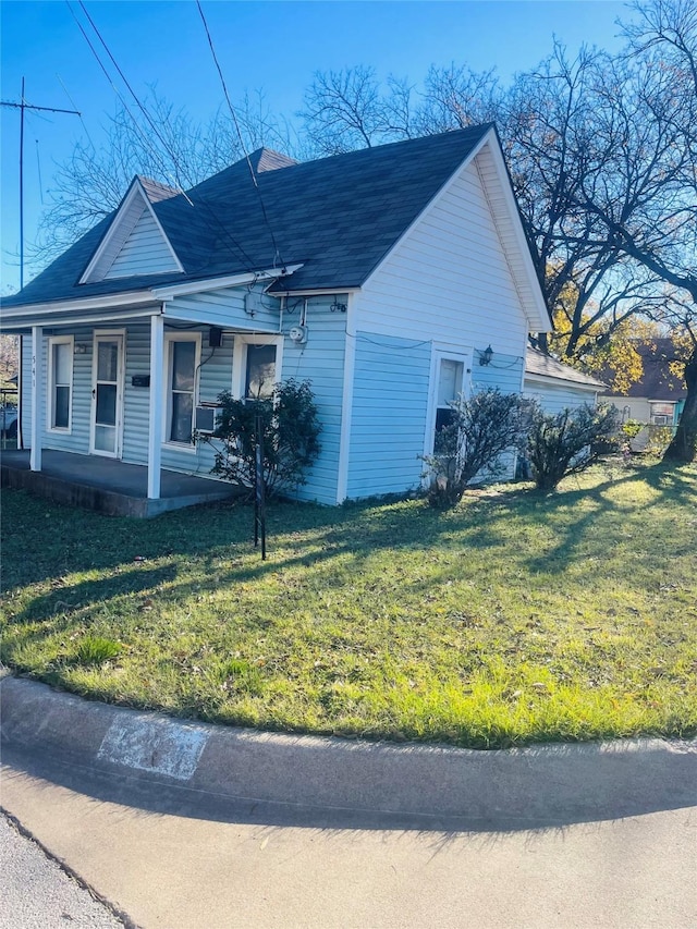 view of side of home featuring a lawn and a porch