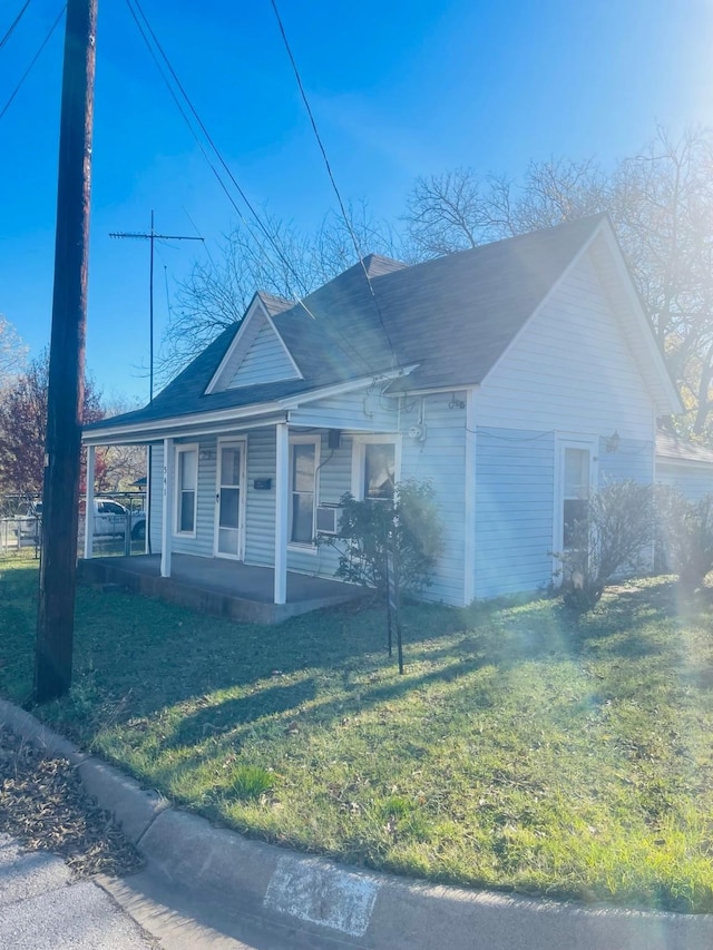 view of front of home featuring cooling unit, a front lawn, and covered porch