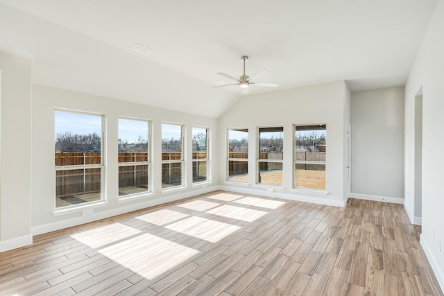 unfurnished sunroom featuring vaulted ceiling, ceiling fan, and plenty of natural light