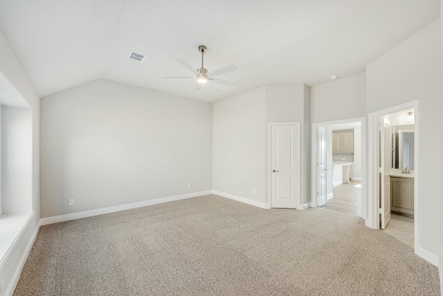 empty room with lofted ceiling, ceiling fan, light carpet, and sink