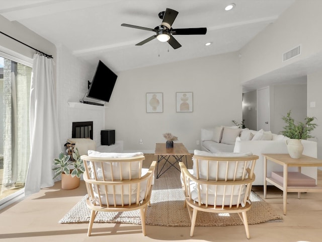 living room featuring vaulted ceiling, a brick fireplace, ceiling fan, and light hardwood / wood-style flooring