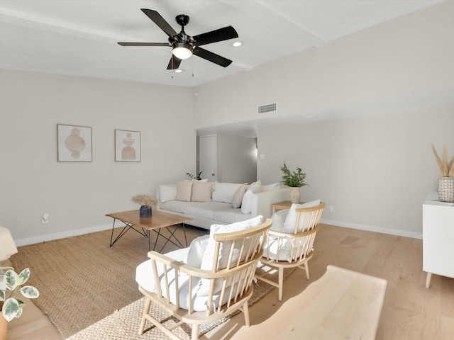 living room with ceiling fan, lofted ceiling, and light hardwood / wood-style floors