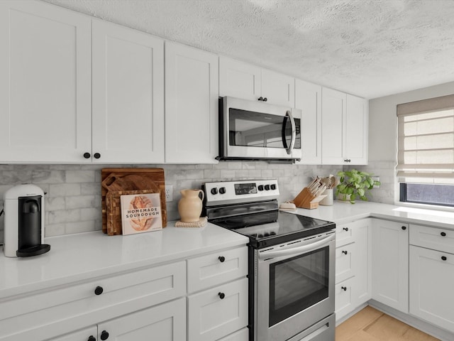 kitchen with white cabinetry, backsplash, a textured ceiling, and appliances with stainless steel finishes