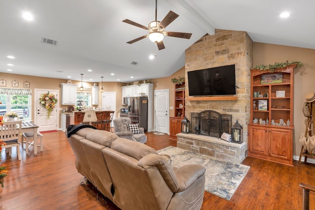 living room featuring lofted ceiling with beams, ceiling fan, dark hardwood / wood-style flooring, and a fireplace