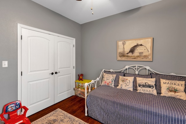 bedroom with dark hardwood / wood-style flooring and a closet