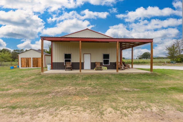 back of house featuring an outbuilding and a yard