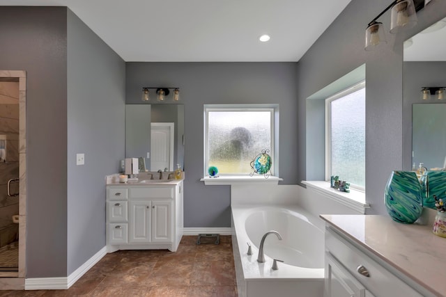 bathroom featuring plus walk in shower, plenty of natural light, and vanity