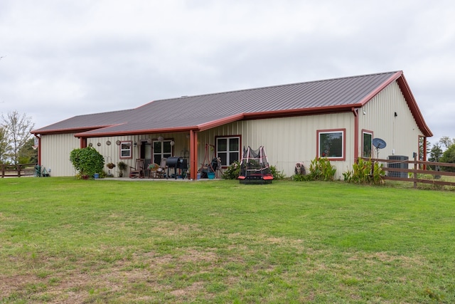 rear view of house featuring a yard and central AC