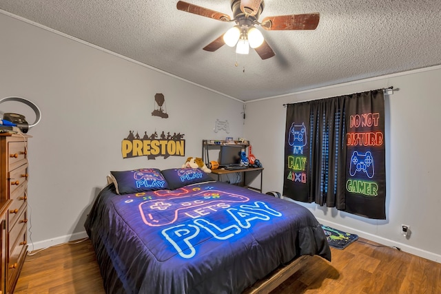 bedroom with ceiling fan, hardwood / wood-style floors, and a textured ceiling