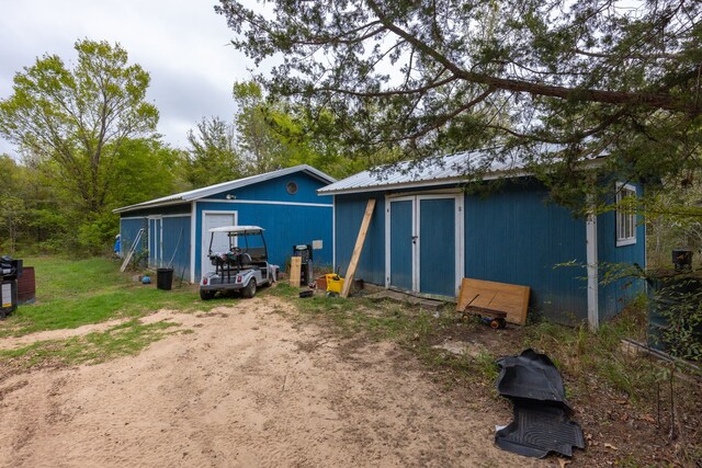 back of house featuring an outbuilding