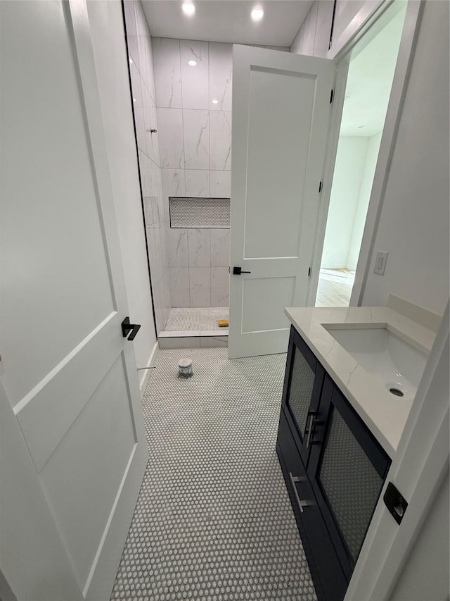 bathroom with a tile shower and sink