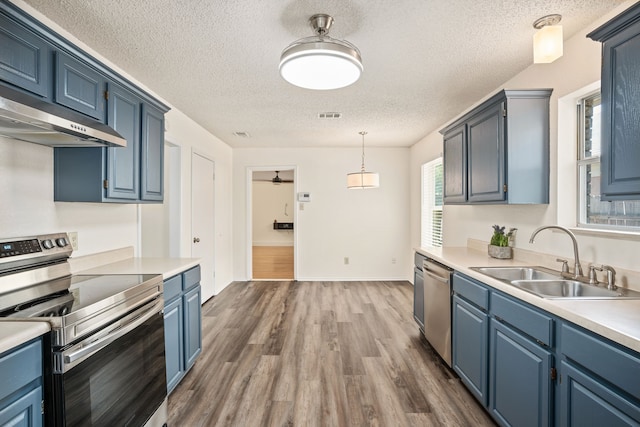 kitchen with appliances with stainless steel finishes, dark hardwood / wood-style flooring, blue cabinets, ceiling fan, and sink