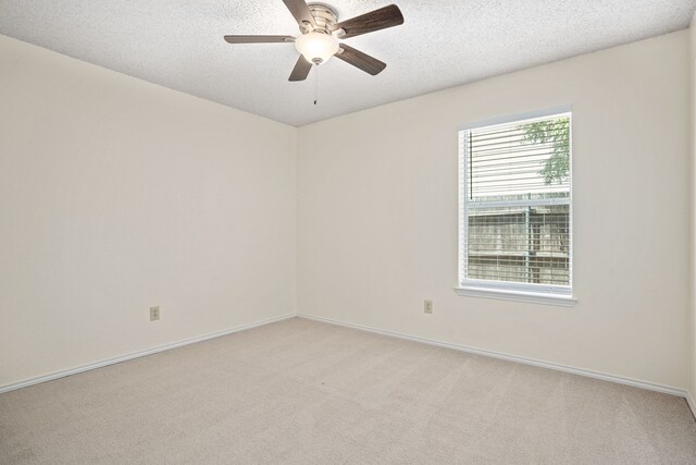 carpeted empty room with ceiling fan and a textured ceiling