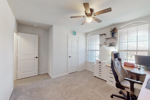 carpeted home office featuring ceiling fan