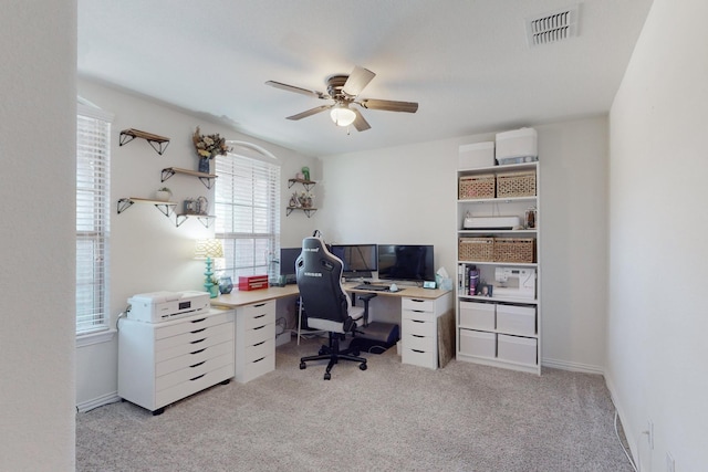 carpeted office space with ceiling fan