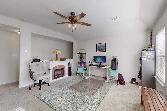 carpeted home office with vaulted ceiling and ceiling fan